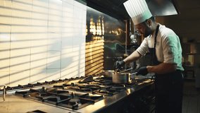 Young professional chef in kitchen while preparing gourmet dishes with a pot - Powered by Shutterstock - Get 15% off with code: PIKWIZARD15