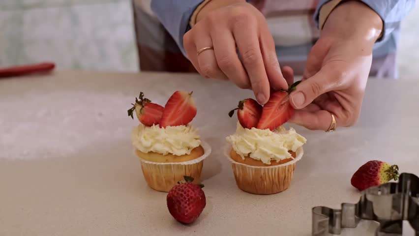A woman pastry chef decorates cupcakes with fruits, strawberry cupcakes, homemade baking, small business, eco-friendly production, gluten-free products, sugar-free, healthy eating.