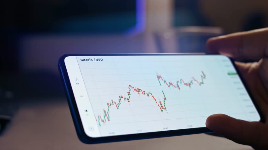 Mobile Crypto Insights, Bitcoin Price Graph on Phone Screen , Gain insights into cryptocurrency investing with a Bitcoin price graph displayed on a mobile phone screen, offering predictions Royalty-Free Stock Footage #3459678335