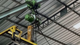The chain on the crane moves when lifting the load. Motor on crane. Working crane.