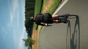 Woman cycling. Professional road cyclist riding bicycle. Female training on road bike at summer, back follow shot. Hard cardio exercises. Vertical video - Powered by Shutterstock - Get 15% off with code: PIKWIZARD15