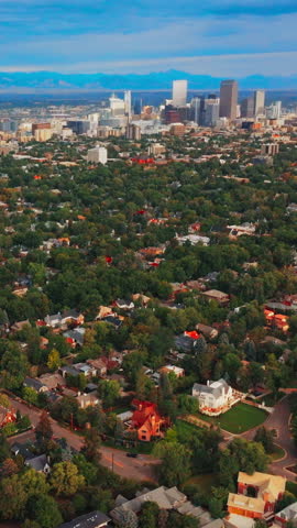 Densely built city scenery with lots of green trees. Panorama of Denver, Colorado with few skyscrapers standing out from usual architecture. Vertical video.