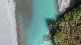 High aerial bird's eye view of beautiful turquoise-colored Waimakariri River in slow-motion (Canterbury, New Zealand)