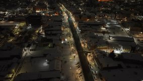 Small town USA with snow and Christmas lights at dawn. High aerial orbit above main street of quaint American town. - Powered by Shutterstock - Get 15% off with code: PIKWIZARD15