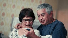 Senior married couple reacting to positive notification message on cellphone device, elderly husband with arm around spouse showing phone and celebrating together - Powered by Shutterstock - Get 15% off with code: PIKWIZARD15