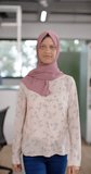 Vertical video of portrait of happy biracial casual businesswoman in hijab in office, slow motion. Casual office, business and work, unaltered.