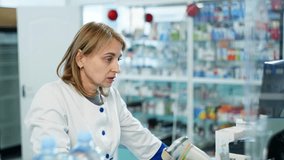 A dedicated female pharmacist in a white coat is seen using a computer to assist with her tasks in a clinical pharmacy setting, showcasing the daily responsibilities of a health care scientist - Powered by Shutterstock - Get 15% off with code: PIKWIZARD15