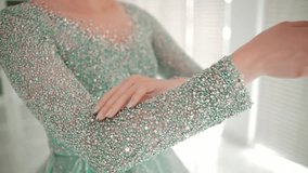 Woman in a glittery dress covering her face with her hand, soft focus background during the morning