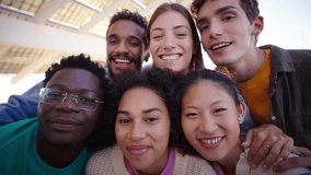 Portrait of a group of young laughing multi-ethnic people are smiling and taking a video selfie together looking at front camera of their smartphone. Diverse friends of generation Z having fun outdoor - Powered by Shutterstock - Get 15% off with code: PIKWIZARD15