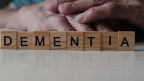 Dementia in adulthood.inscription on wooden cubes dementia and hands of an elderly man.Old age and dementia