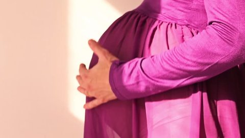 pregnant woman stroking her belly with her hands