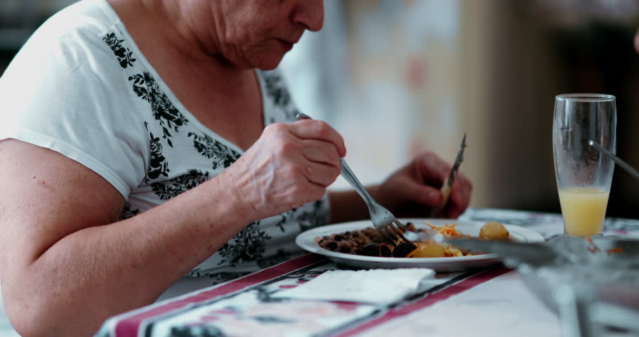 Senior woman eating lunch, close-up plate and hands during mealtime, elderly caucasian 70s person enjoying food Royalty-Free Stock Footage #3459945855
