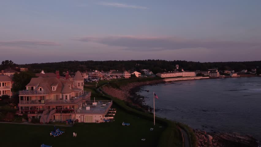 Aerial sunset coastline view of Ogunquit Maine USA drone revealing waterfront luxury house resort 
