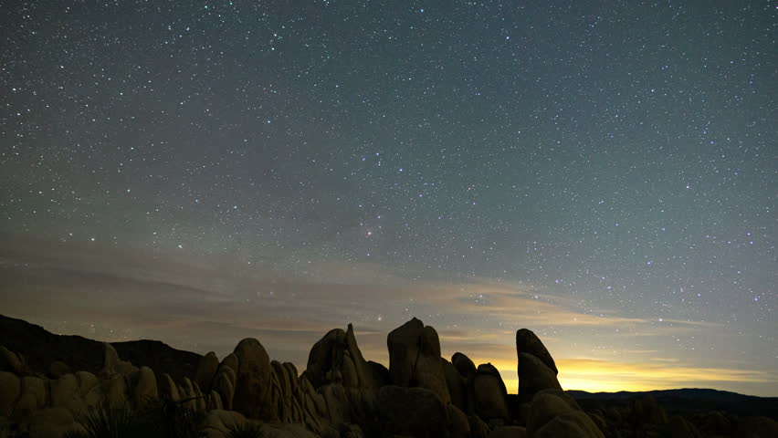 Timelapse of Milky Way galaxy rising over rugged boulders in Joshua Tree National Park, California 