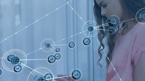 Animation of network of connections with icons over caucasian woman using tablet. Global finance, business, connections, computing and data processing concept digitally generated video. - Powered by Shutterstock - Get 15% off with code: PIKWIZARD15
