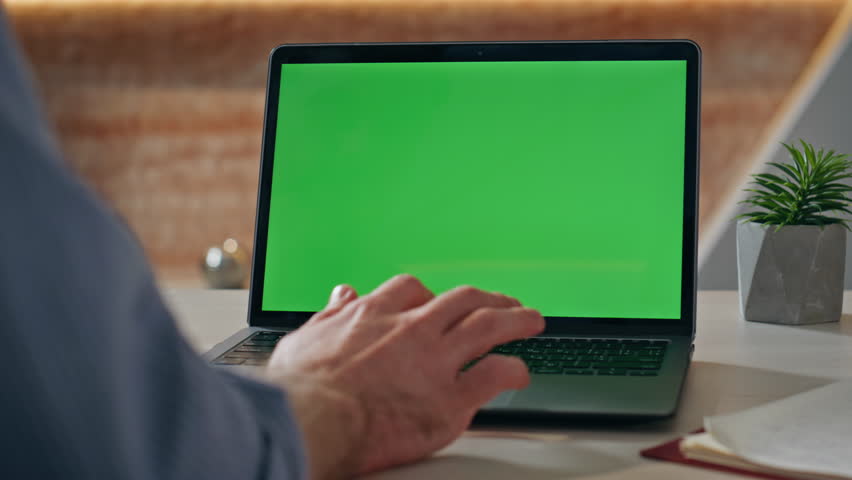 Manager hands scrolling mockup laptop touchpad at office desk closeup. Unknown business person working at chroma key computer on remote job indoors. Freelancer reading email on green screen pc alone