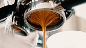 4K Pouring coffee stream from professional machine in cup. Barista man making double espresso, using filter holder. Flowing fresh ground coffee. Drinking roasted black coffee in the morning. - Powered by Shutterstock - Get 15% off with code: PIKWIZARD15