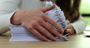 Lady office worker counts contracts secured with paper clips rechecking quantities. Documents for agreement with partners to improve work of corporation