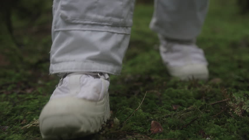 Astronaut in space suit walking trough forest