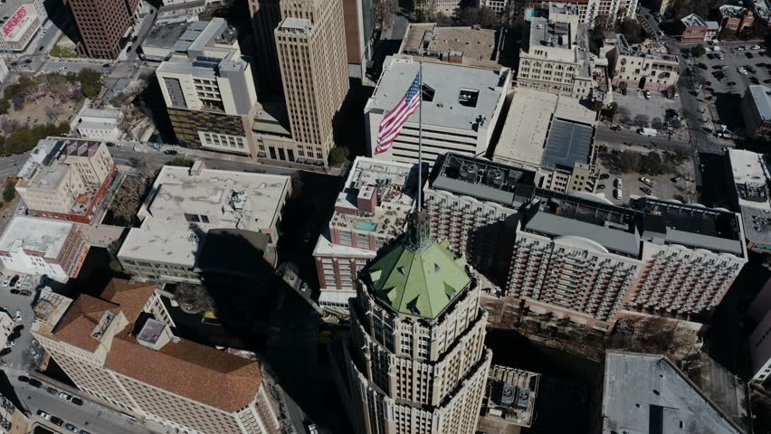 Overhead drone shot of the American flag waving in the wind over San Antonio, Texas.