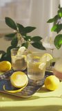 Glasses with water and lemon. Refreshing healthy drinks on the table on a sunny day. Vertical shot