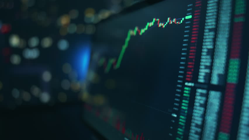 Stock market candles and information of exchange with data of price on the tablet screen. Financial indexes change up and down over time. Concept of trading cryptocurrency assets and bitcoin