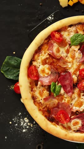 Pizza with thick crust. Meat pizza on a black table with scattered ingredients. Storytelling for a vertical screen. real italian traditional pizza