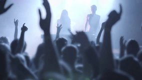 Two beautiful young women DJ play the music on the mixing console in the nightclub. Against the background of unrecognizable people. Slow motion - Powered by Shutterstock - Get 15% off with code: PIKWIZARD15