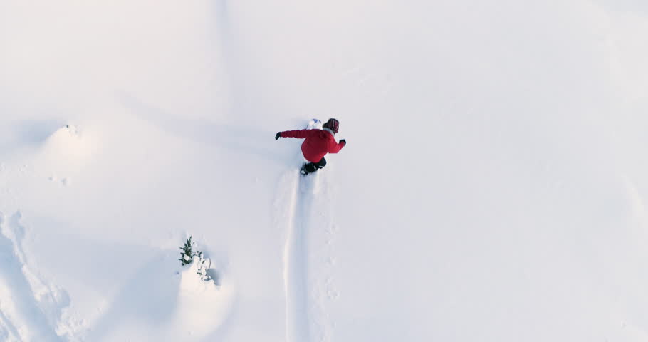 Person Snowboarding Down Slope Drone Aerial Birds Eye View Above White Powder Snow - Winter Extreme Sports Background