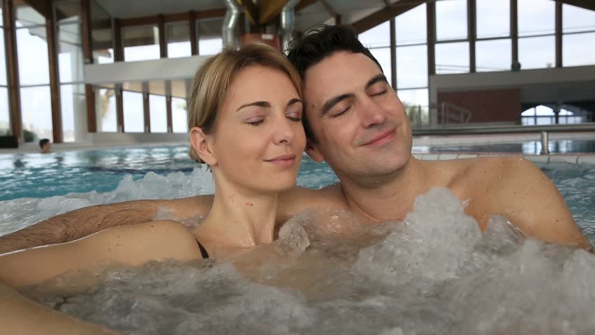 Couple relaxing in hot water tub of spa center
