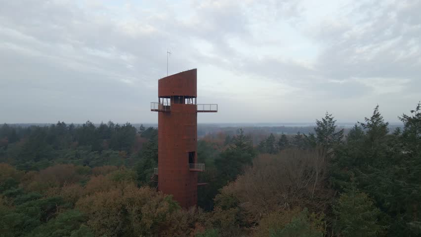 Aerial view of watchtower in middle of autumn forest