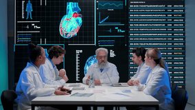 Pharmaceutical research company planning. Multiethnic doctors and scientists having meeting with heart diagnosis data visual graphic on big digital screen. - Powered by Shutterstock - Get 15% off with code: PIKWIZARD15