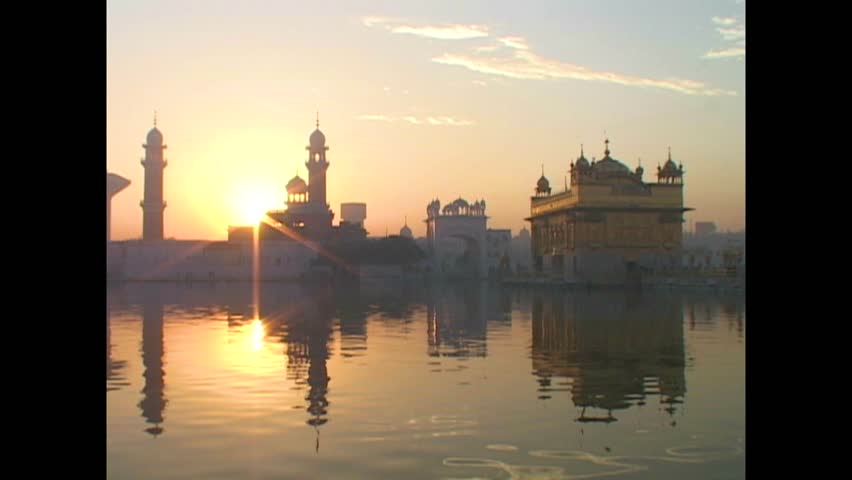 INDIA - 1999 - The sun sets behind India's Golden Temple and its sacred pool. Royalty-Free Stock Footage #3460596941