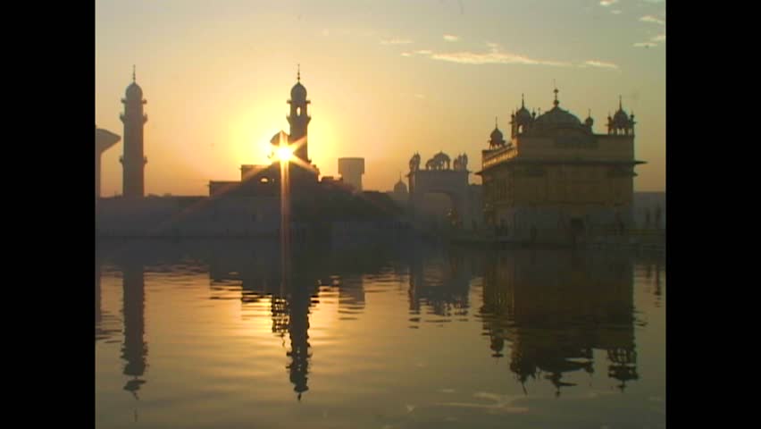 INDIA - 1999 - The waters of the sacred pool outside India's Golden Temple ripple at sunset. Royalty-Free Stock Footage #3460597289