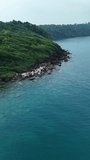 Aerial view of sea waves with rocks and mountains. The sea in Thailand. Aerial view Drone camera top down of seashore rocks in ocean, Amazing sea waves crashing on rocks seascape.