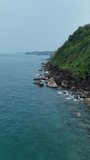 Aerial view of sea waves with rocks and mountains. The sea in Thailand. Aerial view Drone camera top down of seashore rocks in ocean, Amazing sea waves crashing on rocks seascape.