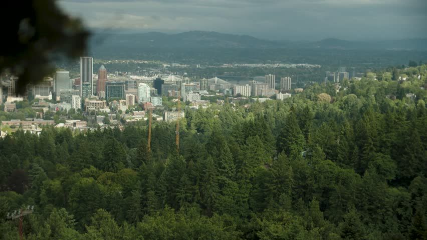 A view of the city of Portland Oregon from the west hills at Pittock Mansion with a forest in the foreground. Royalty-Free Stock Footage #3460630279