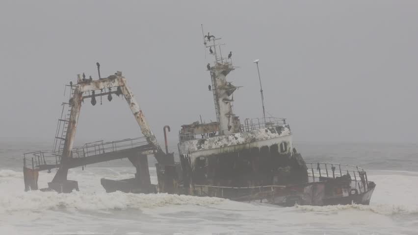 Shipwreck Zeila in the crashing waves at sea from beach near Swakopmund on Namibia Skeleton Coast, Africa under grey solemn sky. Royalty-Free Stock Footage #3460692935