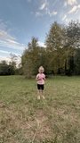 A baby girl jumps in a field. A summer day, a happy child is jumping. A happy family and a small child. The girl is jumping on the grass. High quality HD footage