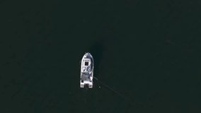 Drone captures fisherman on boat in calm Baltic Sea waters off Kolobrzeg coast on sunny day in February.