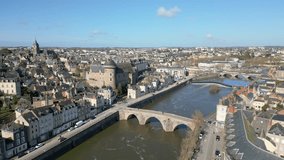 Old bridge crossing Mayenne River with Laval castle. Cityscape and sky for copy space. Aerial drone panoramic view