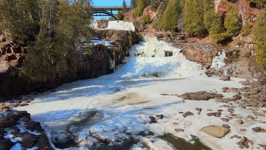 Rocky river in the middle of a snowy forest. Aerial view of Gooseberry Falls, Minnesota.
