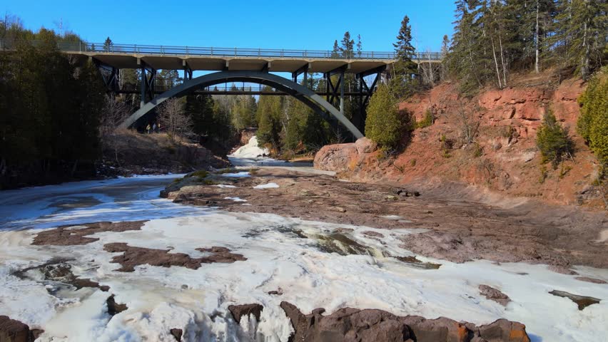 Aeria view frozen river under gooseberry bridge in Minnesota.