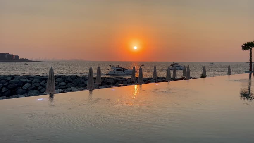 Sunset view of the Dubai Marina and JBR area and the famous Ferris Wheel and golden sand beaches in the Persian Gulf. Holidays and vacations in the UAE. Dubai Marina from the sea side during sunset 