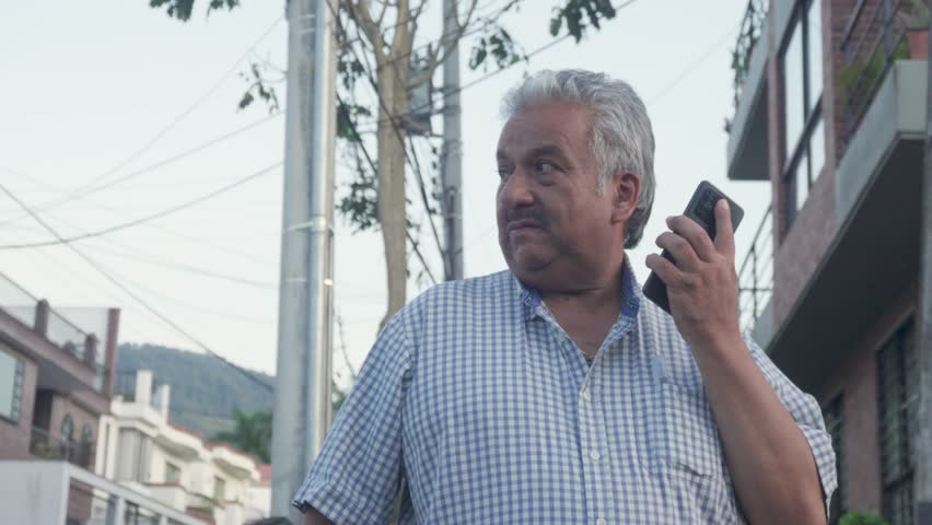 Elderly man navigates streets with smartphone for directions. He moves confidently, utilizing technology to enhance his mobility and independence. 