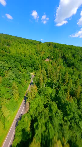FPV drone fast flight over the mountain road in summer in Poland.