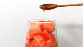 Pour honey using a wooden spoon into the watermelon iced drink.  Fresh watermelon ice drink. - Powered by Shutterstock - Get 15% off with code: PIKWIZARD15