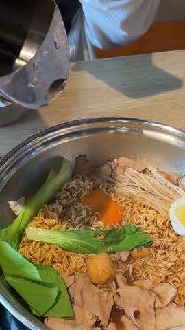 Rotating ramen in the bowl Making traditional Vietnamese soup in a restaurant, choose your own ingredients, add to an iron pan, cook, cook with noodles