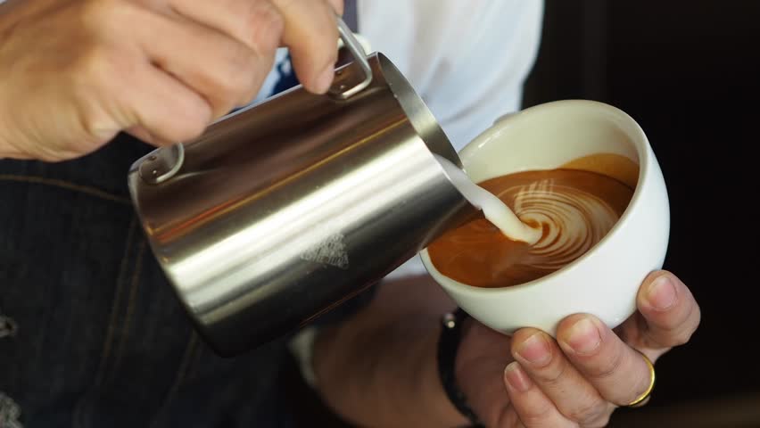 Barista pouring milk in coffee cup for make latte art. | Shutterstock HD Video #34609069