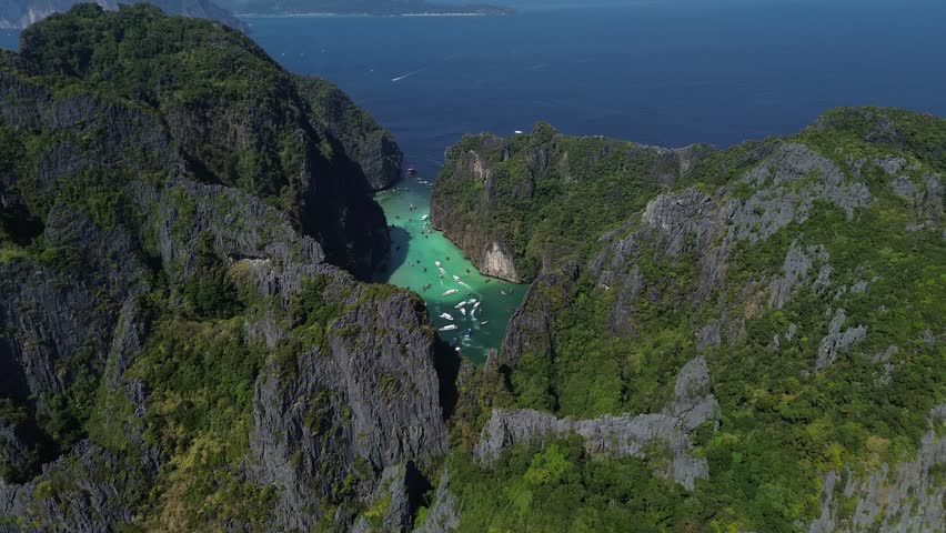 Pileh Lagoon on Phi Phi Ley Island, a popular tourist destination in the south of Thailand, high altitude view of the lagoon and many boats inside Royalty-Free Stock Footage #3460940891